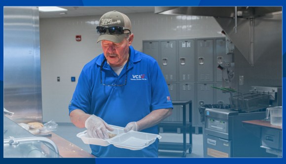A food service worker prepares lunch.