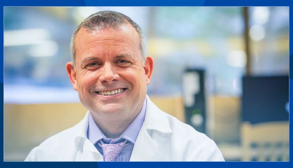 Smiling mental health care provider wears a white lab coat.