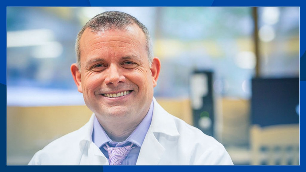Smiling mental health care provider wears a white lab coat.