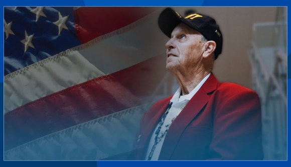 A Veteran stands before an American flag overlay.