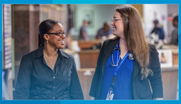 Two VA employees smile at work.