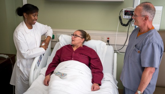 Two clinical providers discuss treatment with a VA patient.