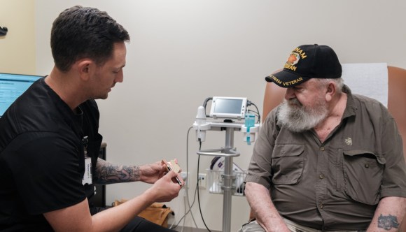 A geriatrics specialist discusses a procedure with an older Veteran.