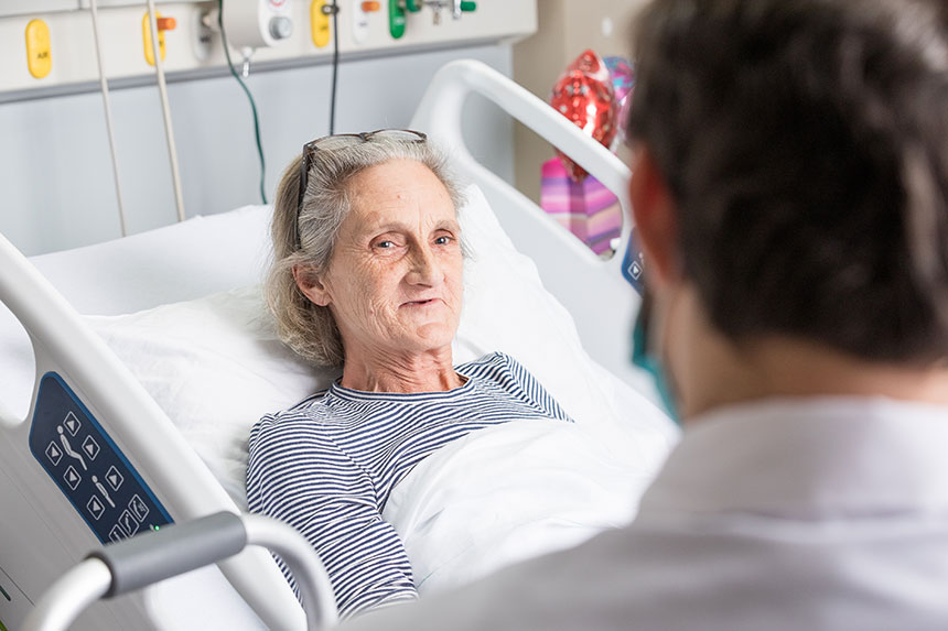 A geriatric female Veteran lies in a hospital bed.