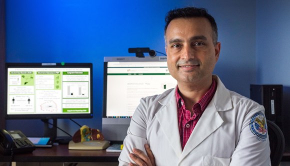 A VA physician standing in front of computer screens, demonstrating our embrace of technology and innovation.