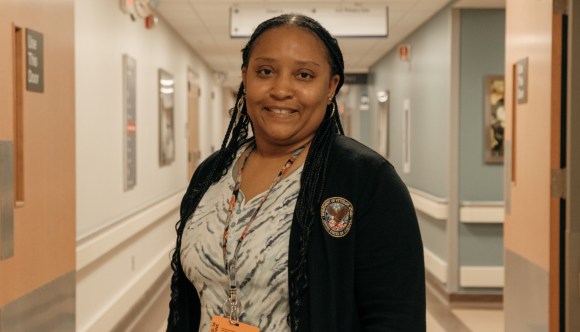 A Black female VA employee in a hallway.