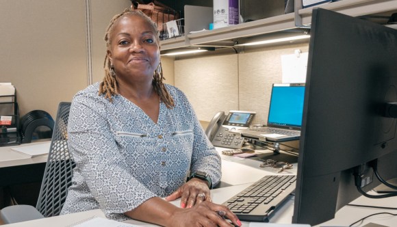 A smiling woman at a computer.