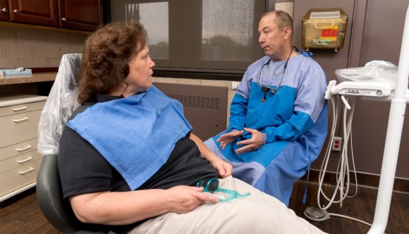 A VA dentist explains a procedure to a Veteran patient.