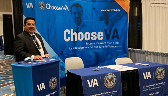 A VA recruiter stands at a booth at one of the national events we attend.